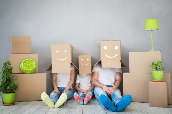 Happy family playing into new home. Father, mother and child having fun together. Moving house day and 